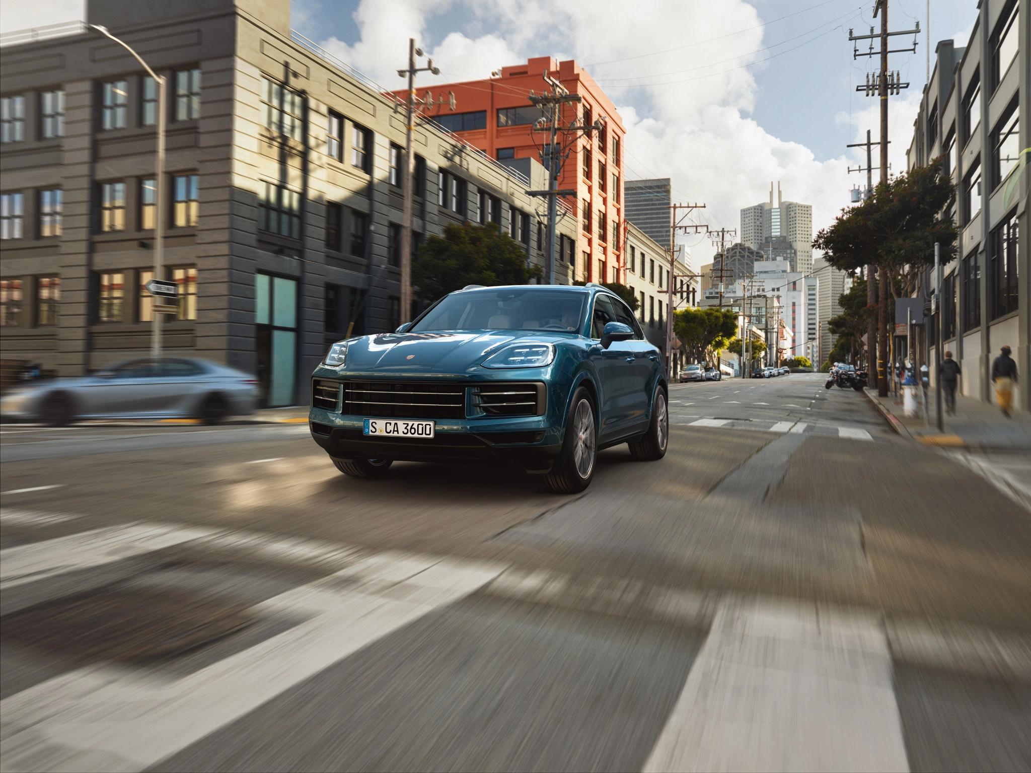 Porsche Cayenne S auf einer Stadt-Straße mit Häusern im Hintergrund